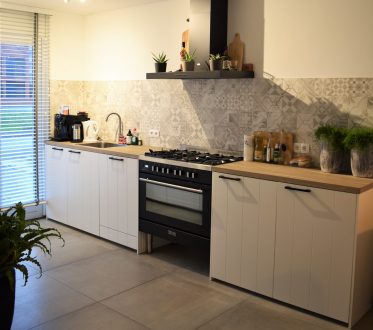 Keuken in Noordwijk met witte kasten en lichte betonlook vloertegels