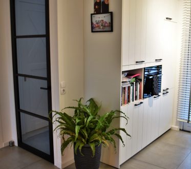 Keuken in Noordwijk met een stalen binnendeur en lichte betonlook vloertegels die doorlopen