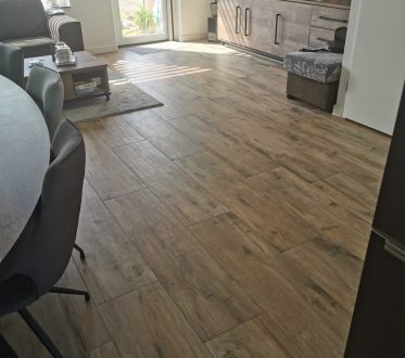 Houtlook vloertegels in een woonkamer in Roelofarendsveen, van dichtbij gefotografeerd