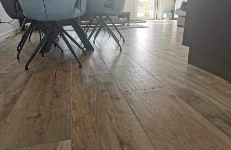 Houtlook vloertegels met een duidelijke nerf in een eethoek in Roelofarendsveen