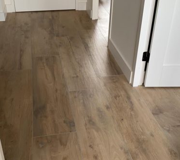 Lichte houtlook vloertegels in een slaapkamer in Noordwijk, van dichtbij