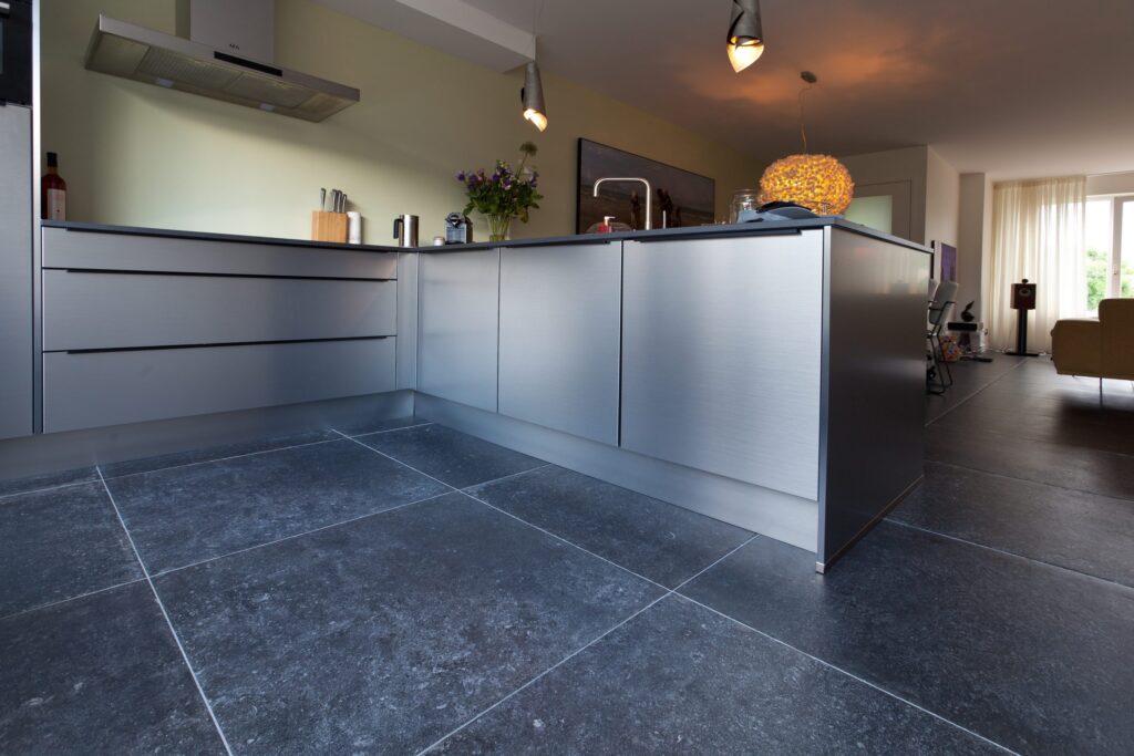 Open keuken in Katwijk met donkere hardsteenlook vloertegels en een lichte keuken