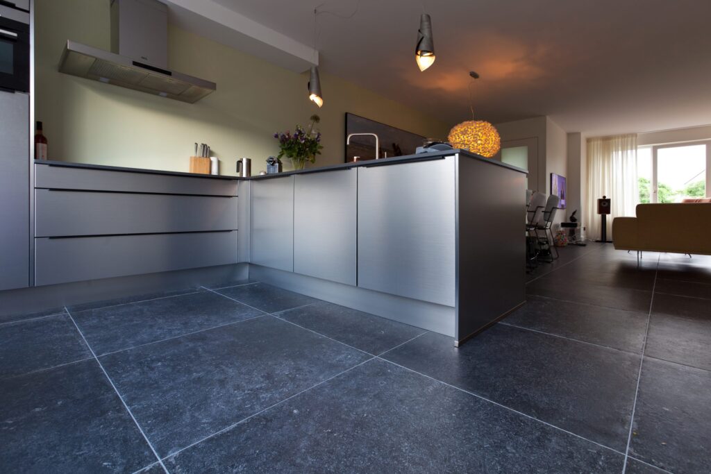Open keuken en woonkamer in Katwijk met donkere hardsteenlook vloertegels