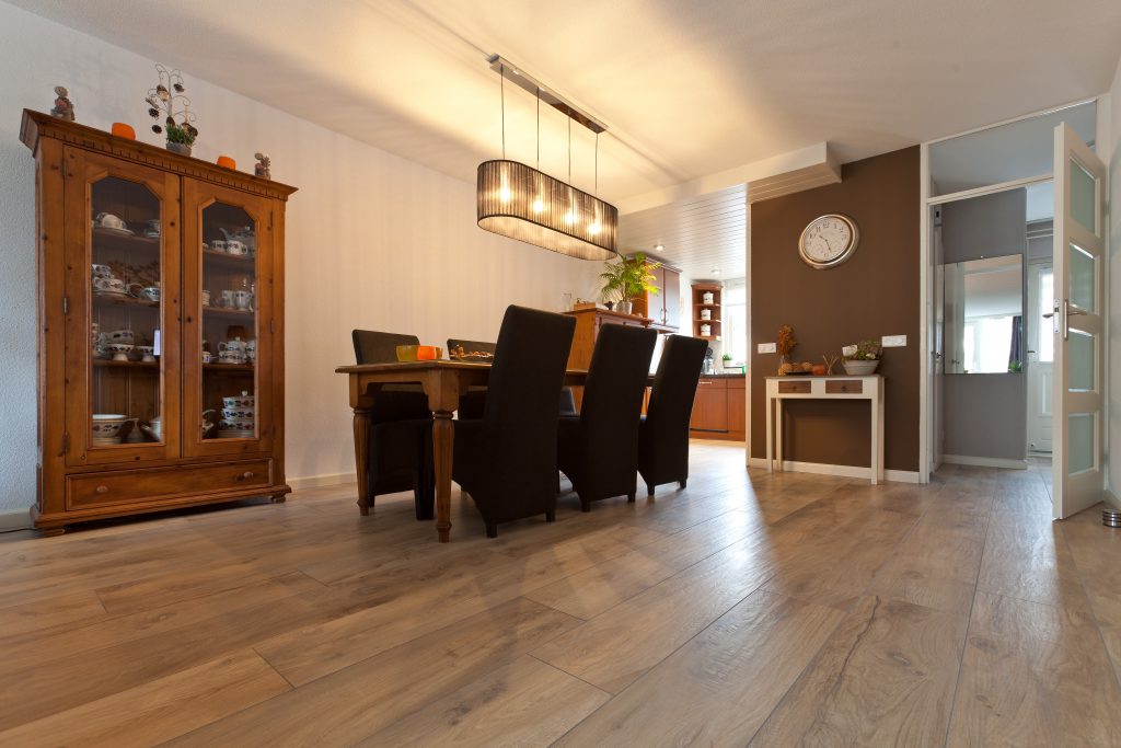 Eetkamer in Hillegom met houtlook vloertegels en een antieke houten vitrinekast