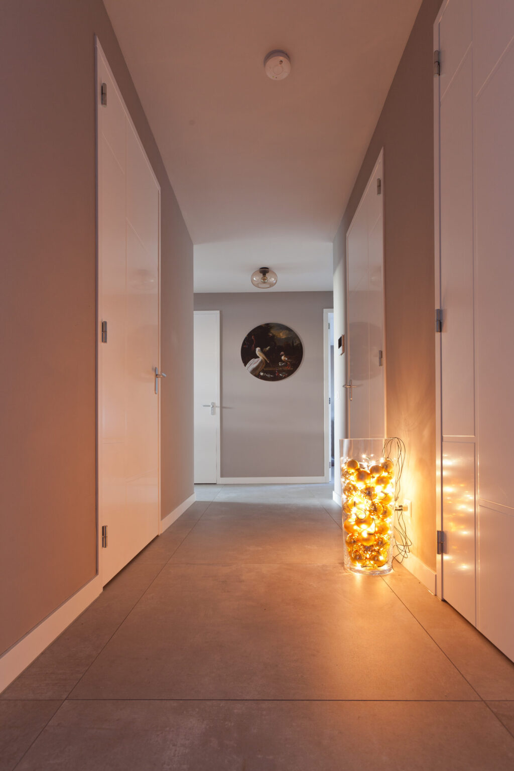 Gang in Noordwijk met grote betonlook vloertegels van 100×100 en sfeerverlichting
