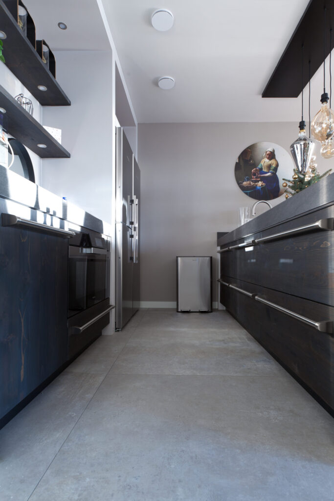Keuken in Noordwijk met grote betonlook vloertegels van 100×100 en zwarte keukenkasten