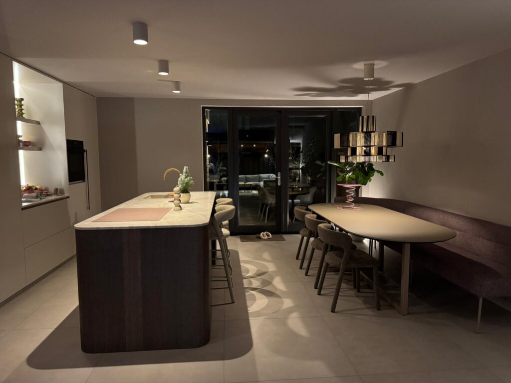 Kookeiland met barkrukken en een lange eettafel op zandgrijze betonlook tegels van 90×90 in Sassenheim