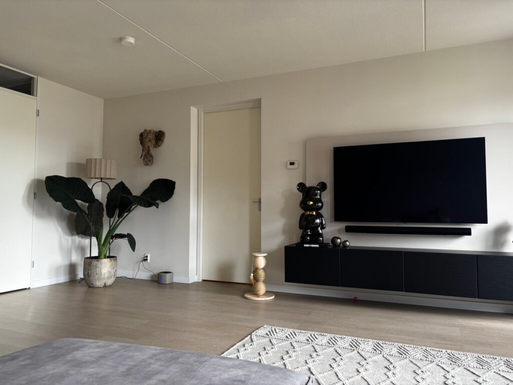 Zithoek met tv-wand op een klik PVC vloer in lichte houtlook in een appartement in Valkenburg