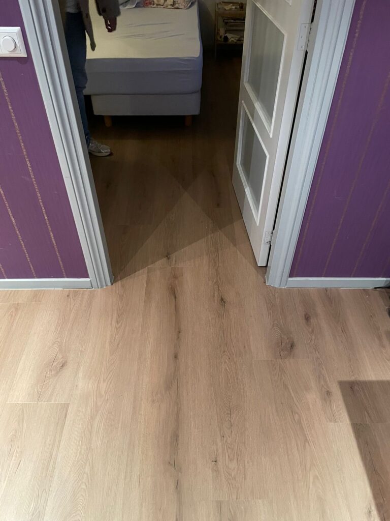 Klik PVC vloer in houtlook die zonder drempel doorloopt van de overloop naar de slaapkamer in Katwijk