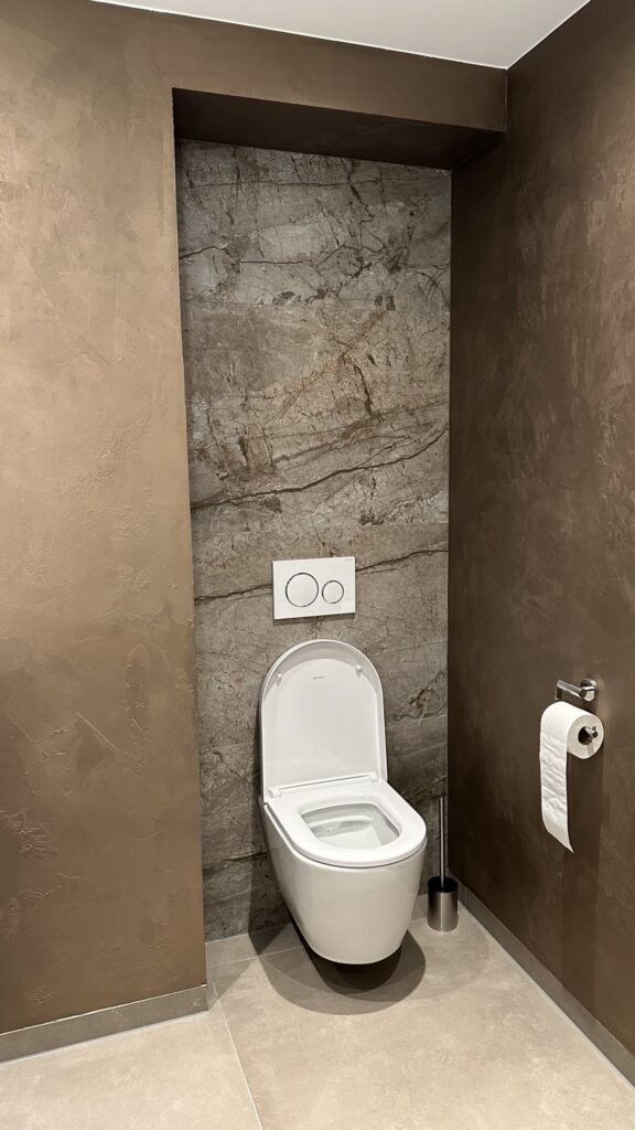 Hangend toilet voor een wand van grijze marmerlook tegels van 60×120 in een badkamer in Voorhout